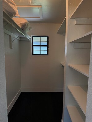 A narrow hallway with a window, a white wall, and a black floor. - The Cozy Cabin- 2 large bedrooms surrounded by views of old Florida (Williston)