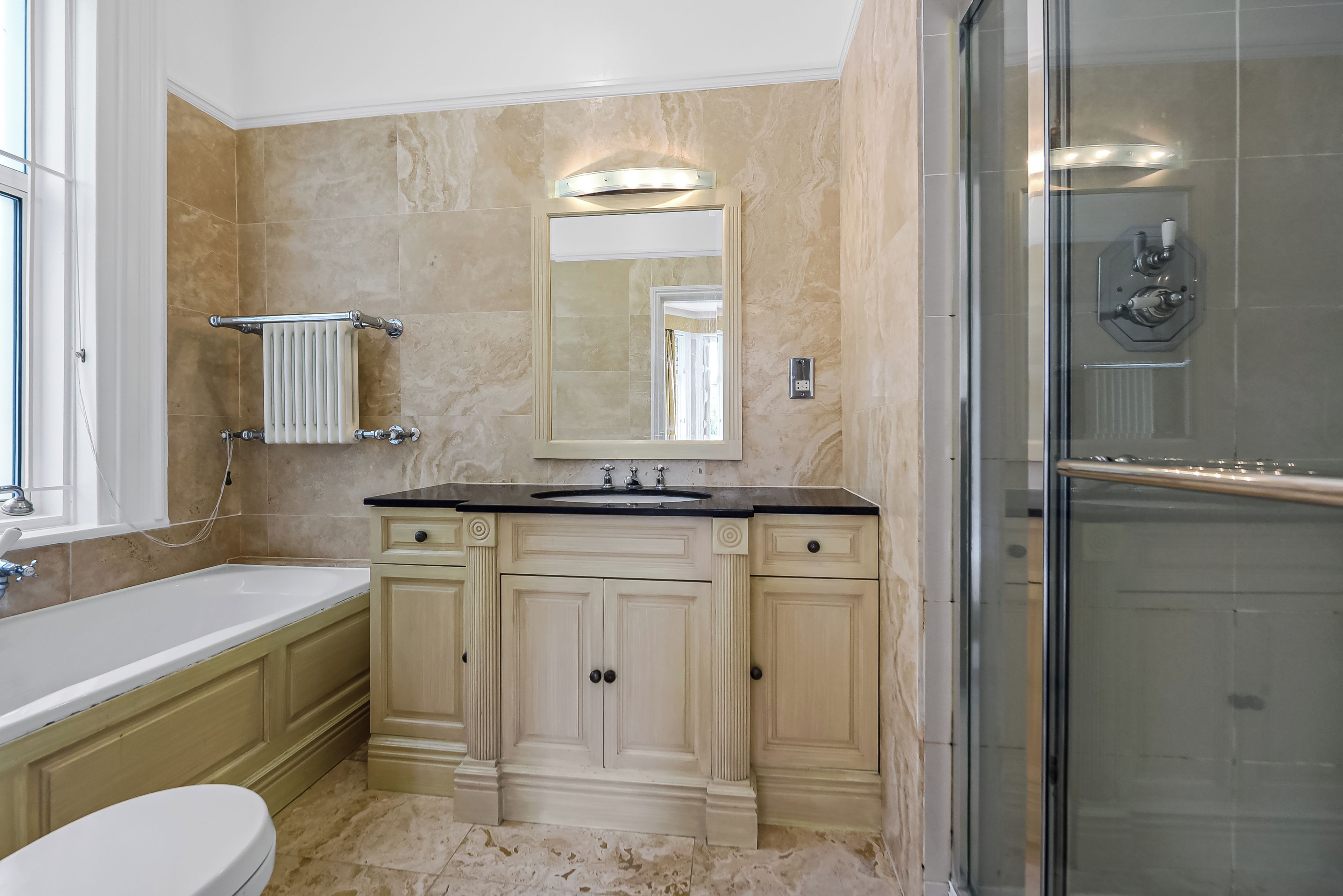 A bathroom with a bathtub, a sink, a mirror, and a shower.
