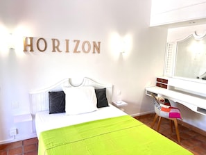 A bedroom with a bed, a desk, and a chair. The word 'HORIZON' is displayed on the wall. - New Listing (La Trinité)