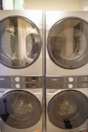 A set of four Whirlpool washing machines. - Luxury Warm Modern Retreat in Utica Square w/ 2 King Suites, 3 Patios & Spa Bath (Tulsa)