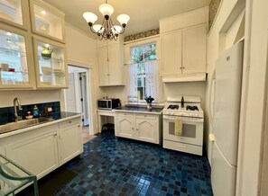 A kitchen with white cabinets, a gas stove, a microwave, and a refrigerator. - Easy SF Access from Spacious apartment in Sausalito with stunning views (Sausalito)