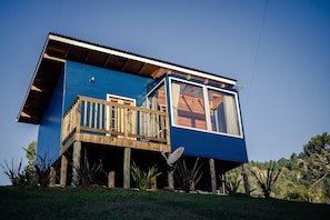 A two-story house with a wooden deck, large windows, and a satellite dish. - Blue Sunset 3 (Urubici)