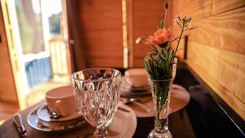 Une table dressée avec un verre, une tasse et un vase rempli de fleurs.