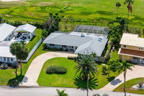 A residential area with multiple houses, a well-maintained lawn, and a clear sky. - 6 Country Club Rd (Cocoa Beach)