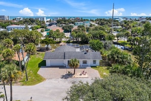 A residential property with a large house, a driveway, and a small dock by a body of water. - 122 Sunset Dr (Cocoa Beach)
