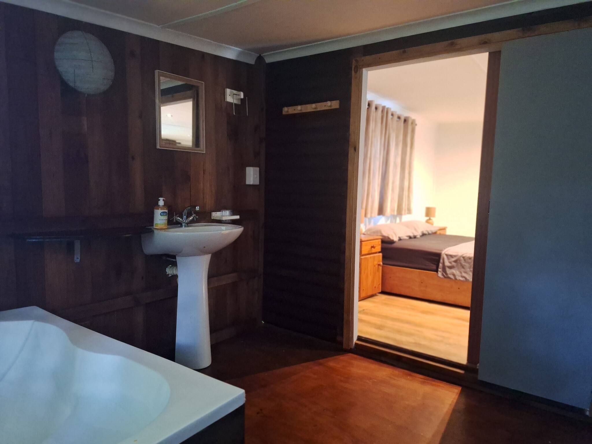 A bathroom with a bathtub, sink, and mirror.
