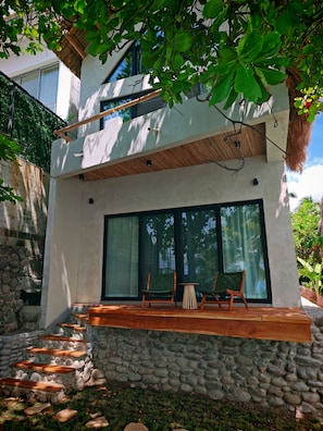 Een modern huis met een stenen trap die leidt naar een houten terras.