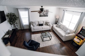 A modern living room with a sofa, coffee table, and a ceiling fan. - Lovely 3br/2.5ba Home Six Flags/La Cantera/USAA/UTSA (San Antonio)