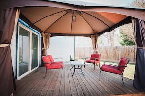 A covered patio with a table and chairs, a sliding glass door, and a wooden deck. - Lovely 3br/2.5ba Home Six Flags/La Cantera/USAA/UTSA (San Antonio)