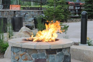 A stone fire pit with flames, surrounded by greenery and a closed sign in the background. - CANYON VILLAGE/CLUB WYNDHAM PARK CITY, 3BR, FEB 6-9,2027, GREATEST SNOW ON EARTH (Park City)