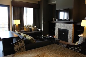 A hotel room with a living area featuring a sofa set, a flat-screen TV, a fireplace, and a coffee table. - CANYON VILLAGE/CLUB WYNDHAM PARK CITY, 3BR, FEB 6-9,2027, GREATEST SNOW ON EARTH (Park City)
