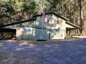 Ein Holzhaus mit Garage, überdachter Veranda und Fahnenmast mit der US-amerikanischen Flagge.