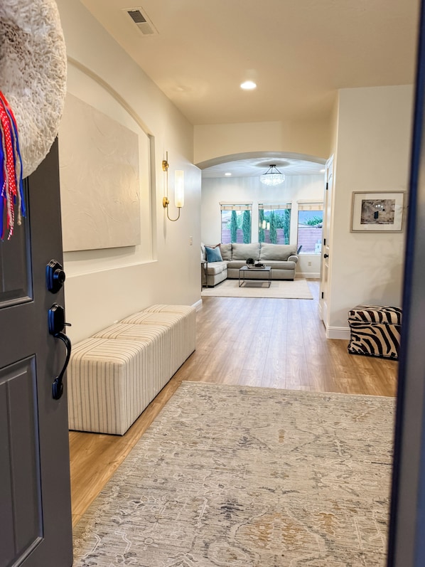 A spacious living room with a sectional sofa, a bench, and a zebra-patterned ottoman. - Charming House in Little Valley (St. George)