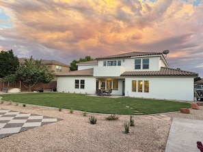 A two-story house with a patio, a lawn, and a driveway. - Charming House in Little Valley (St. George)