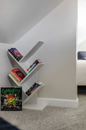 Un escalier blanc avec une bibliothèque sur le côté gauche.