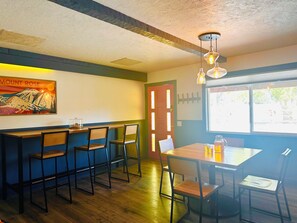 A restaurant interior with a bar area, wooden chairs, a table with a glass pitcher, and a painting on the wall. - Cozy Reno/Tahoe 3-bedroom House - Pet Friendly! (Reno)