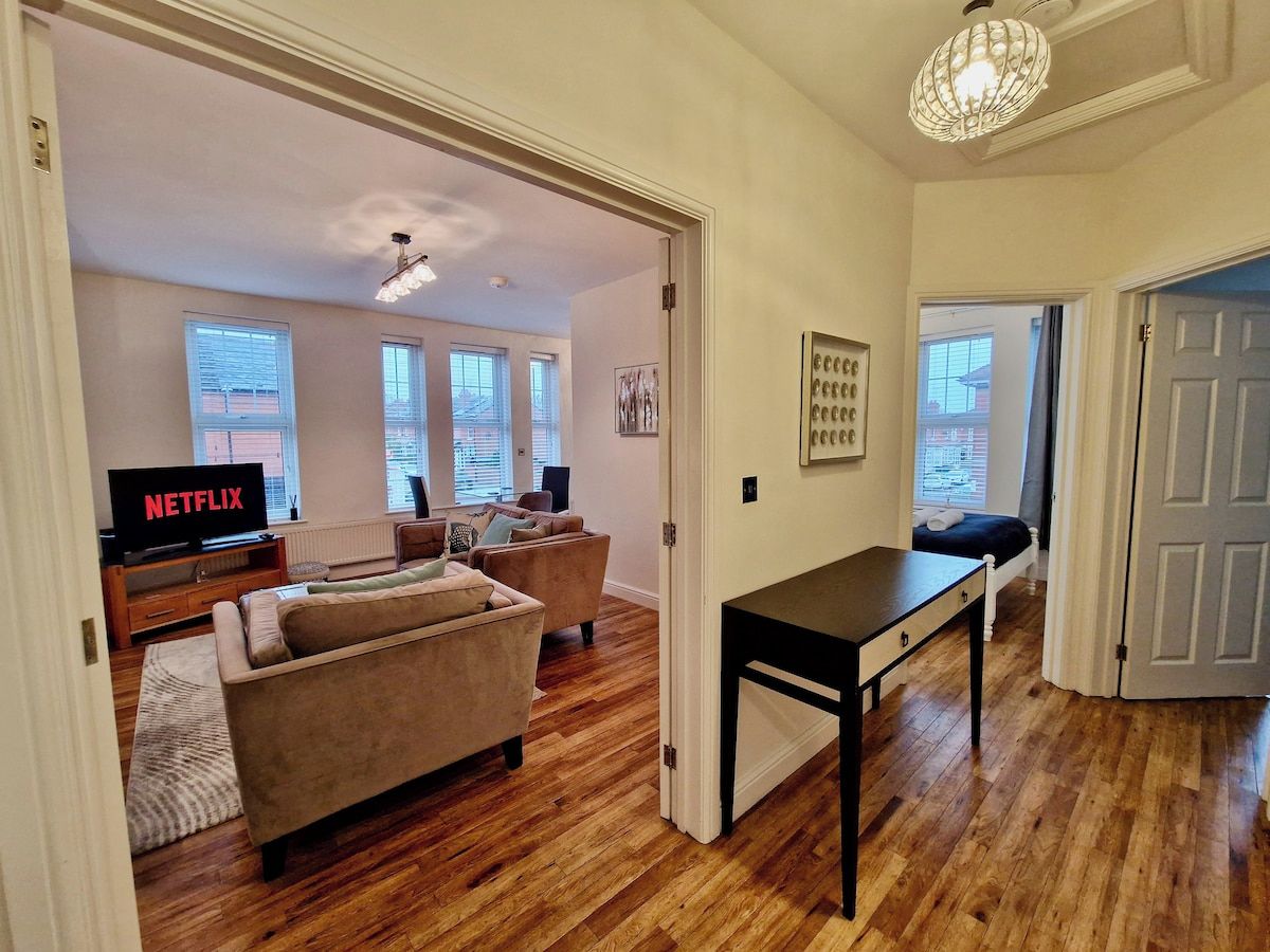 A living room with a sofa, a TV, and a table.