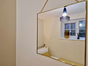 A bathroom with a mirror, a window, and a hanging light fixture. - Stylish Apt in Trendy Earlsdon, Free Parking (Coventry)