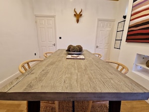 A long dining table with chairs, a decorative bowl, and a mounted animal head on the wall. - Luxurious & Cosy Home w/ Free Parking and Garden (Coventry)