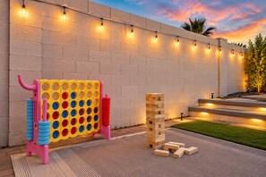 Eine Ziegelwand mit Lichterketten, eine farbenfrohe Spielkonstruktion und ein hölzerner Jenga-Turm.