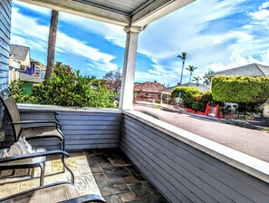 A covered porch with a view of a street, a chair, and a potted plant. - Historic Craftsman Home - Coronado Bridge Views - Near Downtown (San Diego)