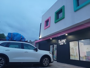 A white car parked in front of a building with a sign that reads 'Suits Hotel Boutique.' - New Listing (Nuevo Casas Grandes)