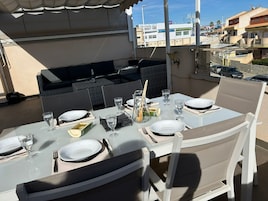 Una mesa de comedor al aire libre con vistas a edificios en el fondo.