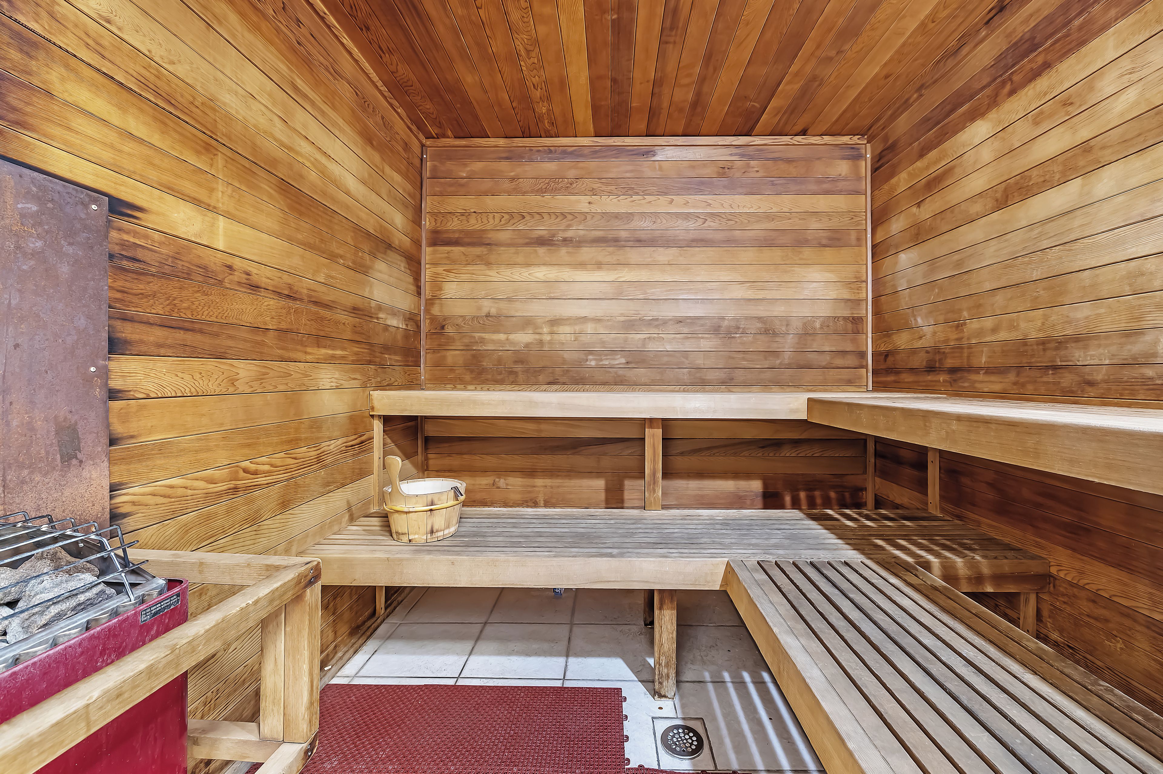 Un sauna avec des bancs en bois et un mur en bois.