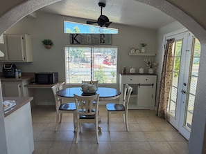 A compact kitchen with a dining table, chairs, a microwave, and a ceiling fan. - 3-bedroom, King bed in spacious condo (Wildomar)