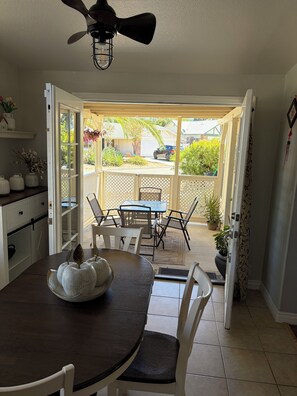 An open door leading to a patio with a table and chairs, a ceiling fan, and a view of the outside. - 3-bedroom, King bed in spacious condo (Wildomar)