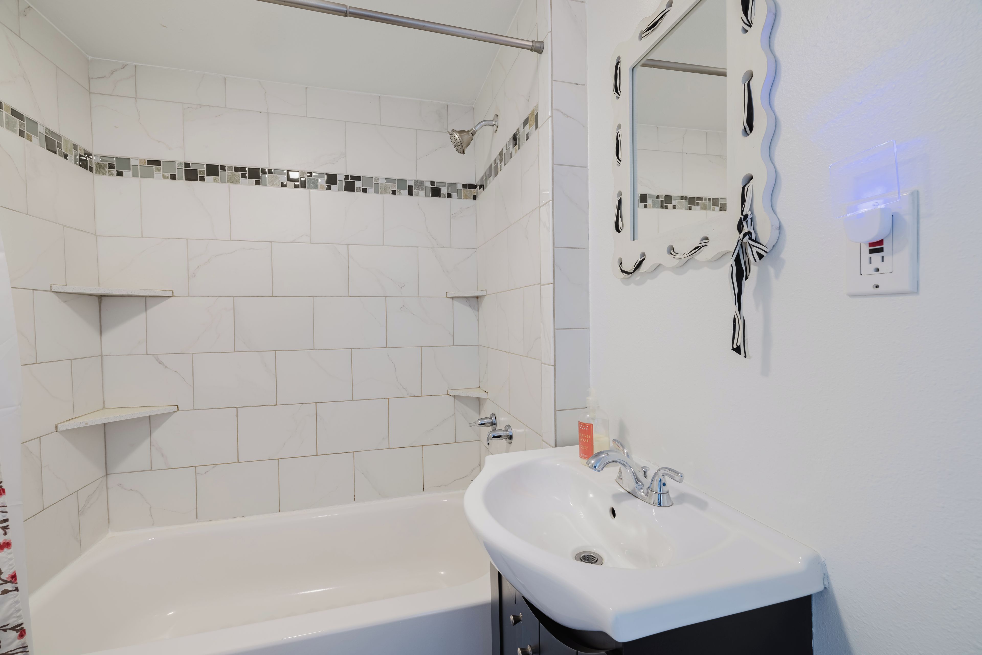 Une salle de bain moderne avec une baignoire, un lavabo et un espace douche.