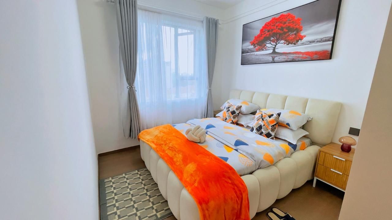 A bedroom with a bed, a nightstand, a lamp, and a window with curtains.