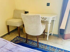 A room with two chairs, a small white table, and a patterned rug. - Double Room + Pool View (Tassoultante)