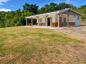 A single-story house with a covered porch, a brick exterior, and a grassy yard. - New Listing (Sainte-Luce)