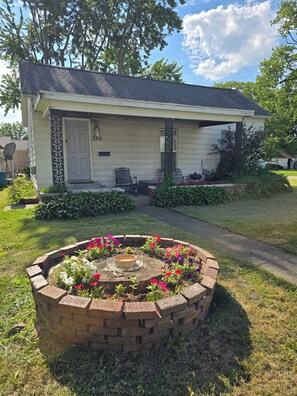 A single-story house with a front porch, a brick flower bed, and a mailbox. - Carico Comfortable Family Home Near Champaign (Tuscola)