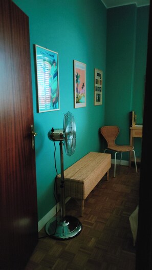 A room with a wooden door, a bench, a standing fan, and wall-mounted pictures. - New Listing (Ravenna)