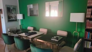 A room with a green wall, a poster, a bookshelf, and a desk with a laptop. - New Listing (Ravenna)