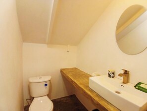 Ein kleines Badezimmer mit Toilette, Waschbecken und Spiegel.