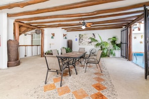 A dining area with a table and chairs, a ceiling fan, and a wall with decorative items. - Cozy 2BR Condo in Downtown Playa del Carmen Prime Location (Playa del Carmen)