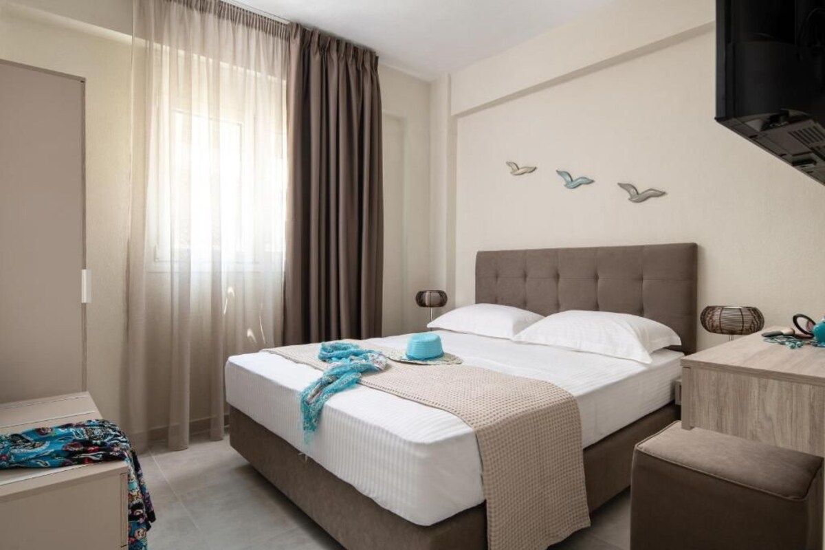 A hotel room with a bed, a desk, and a chair.
