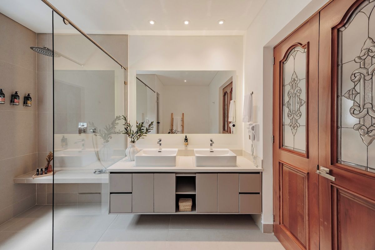 Primary Suite - Ensuite Bathroom : Elegant master bathroom with double sinks, hair dryer, and premium L’Occitane amenities including shampoo, shower gel, and conditioner—designed for comfort and luxury.