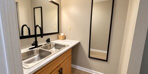 A bathroom with two sinks, a mirror, and a wooden cabinet.
