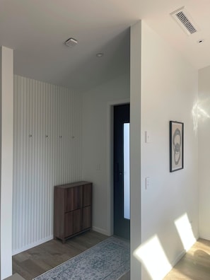 Une pièce avec un meuble en bois, un tapis à motifs et un tableau encadré accroché au mur.