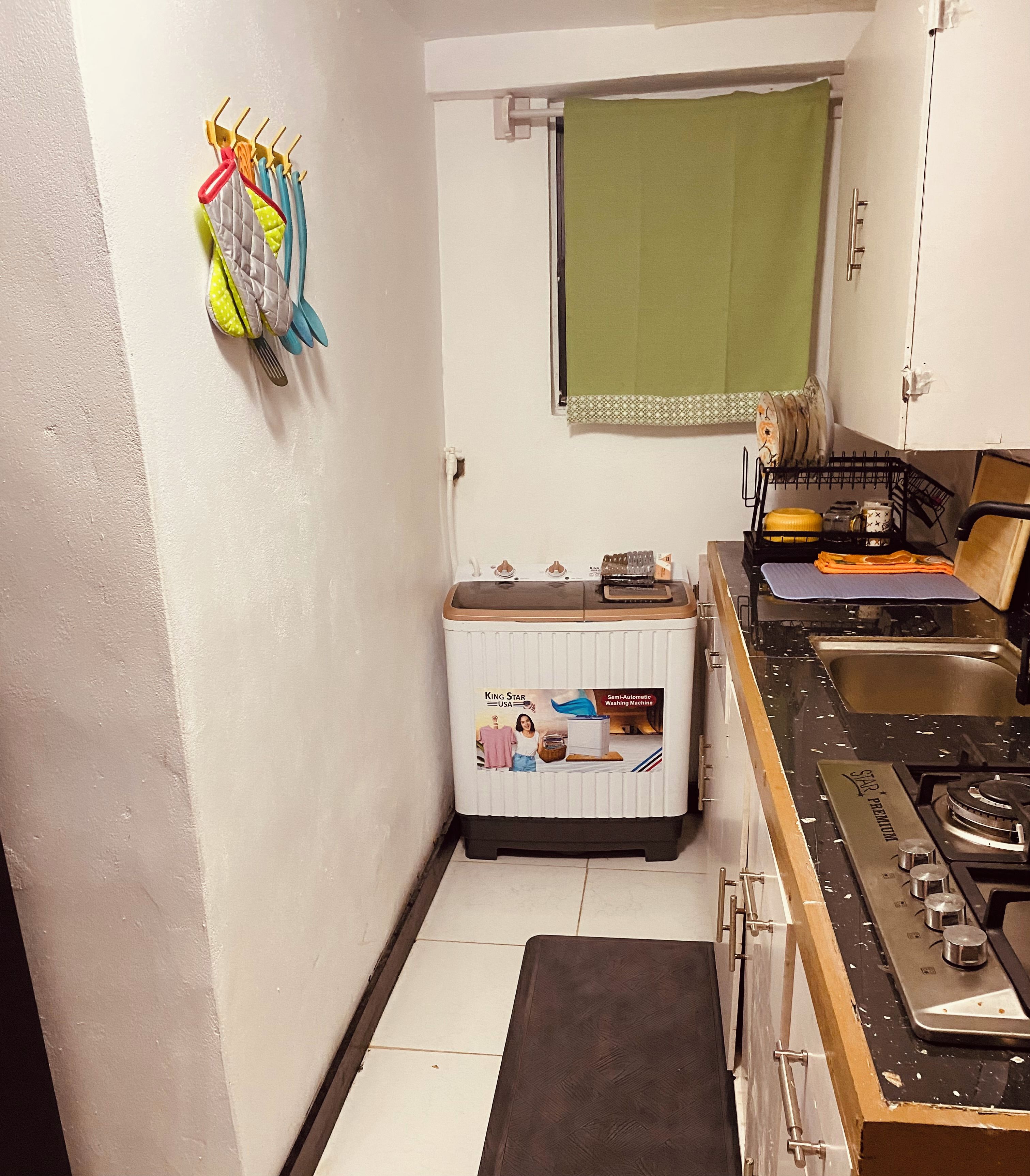 A compact kitchen with a stove, sink, and a small refrigerator.