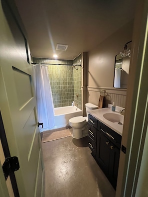 A bathroom with a bathtub, toilet, and sink.