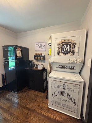 A room with a refrigerator, a coffee bar sign, and a laundry room sign. - Suite Carolyn located in the historic Mc Coy Place Lofts. (Cave City)