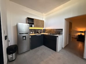 Uma cozinha compacta com forno embutido, pia e bancada.