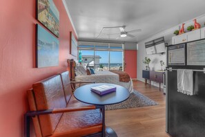 A modern hotel room with a balcony, a bed, a desk, and a refrigerator. - Oceanfront Studio: Boardwalk, Beach, & Pool Views
WiFi & Free Parking Included (Virginia Beach)