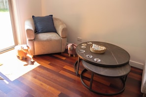 A room with a round table, a sofa, a small rug, and a window. - School house by the bay, beach walks, large yard, happy paws (Rippleside)