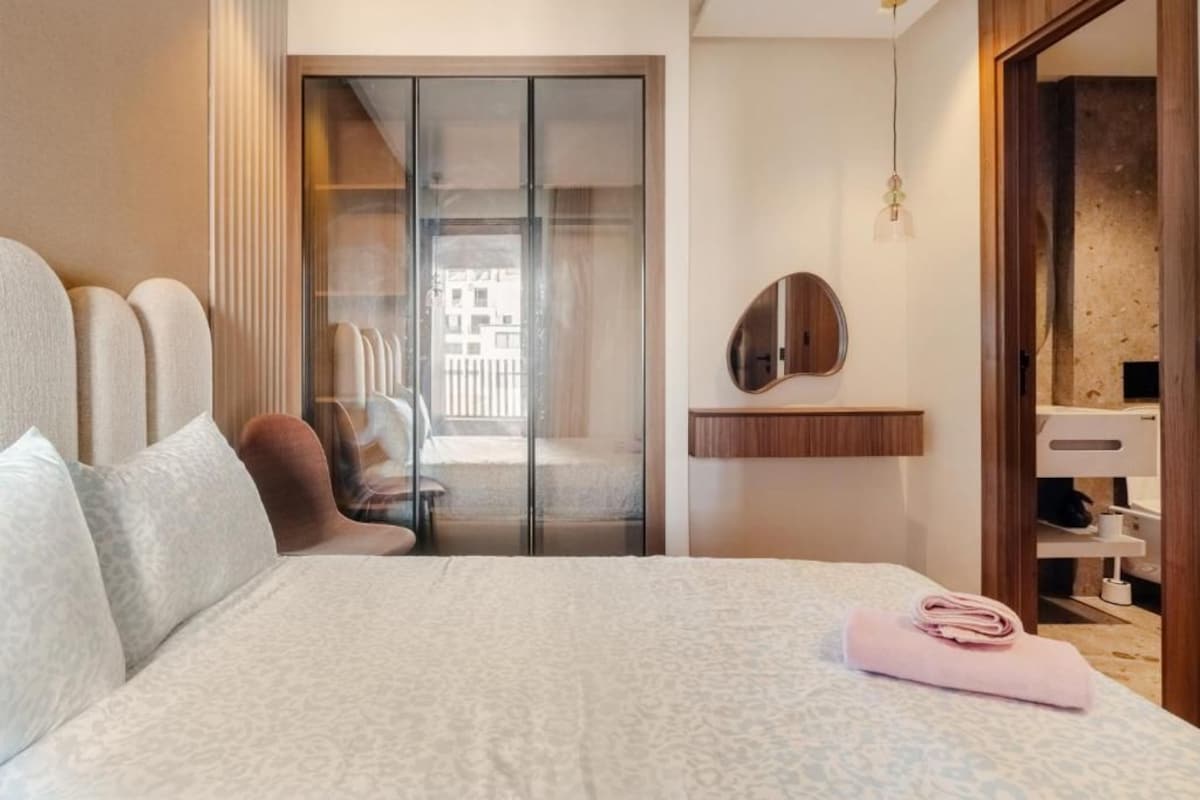 Ein Hotelzimmer mit Bett, Spiegel, Kleiderschrank und Blick ins Freie.